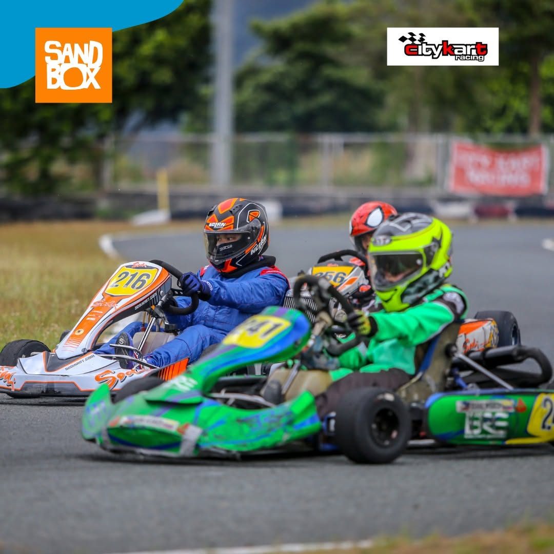 Helmeted drivers racing go-karts at SandBox at Alviera
