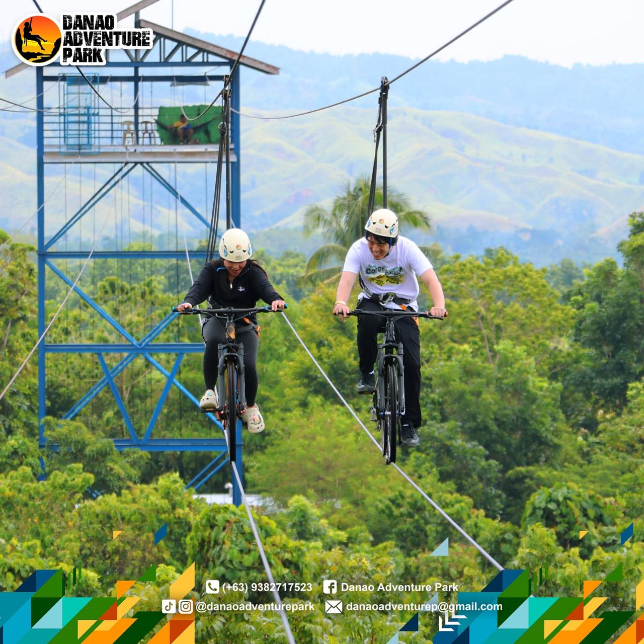 Two visitors riding bicycles along elevated cables at Danao Adventure Park