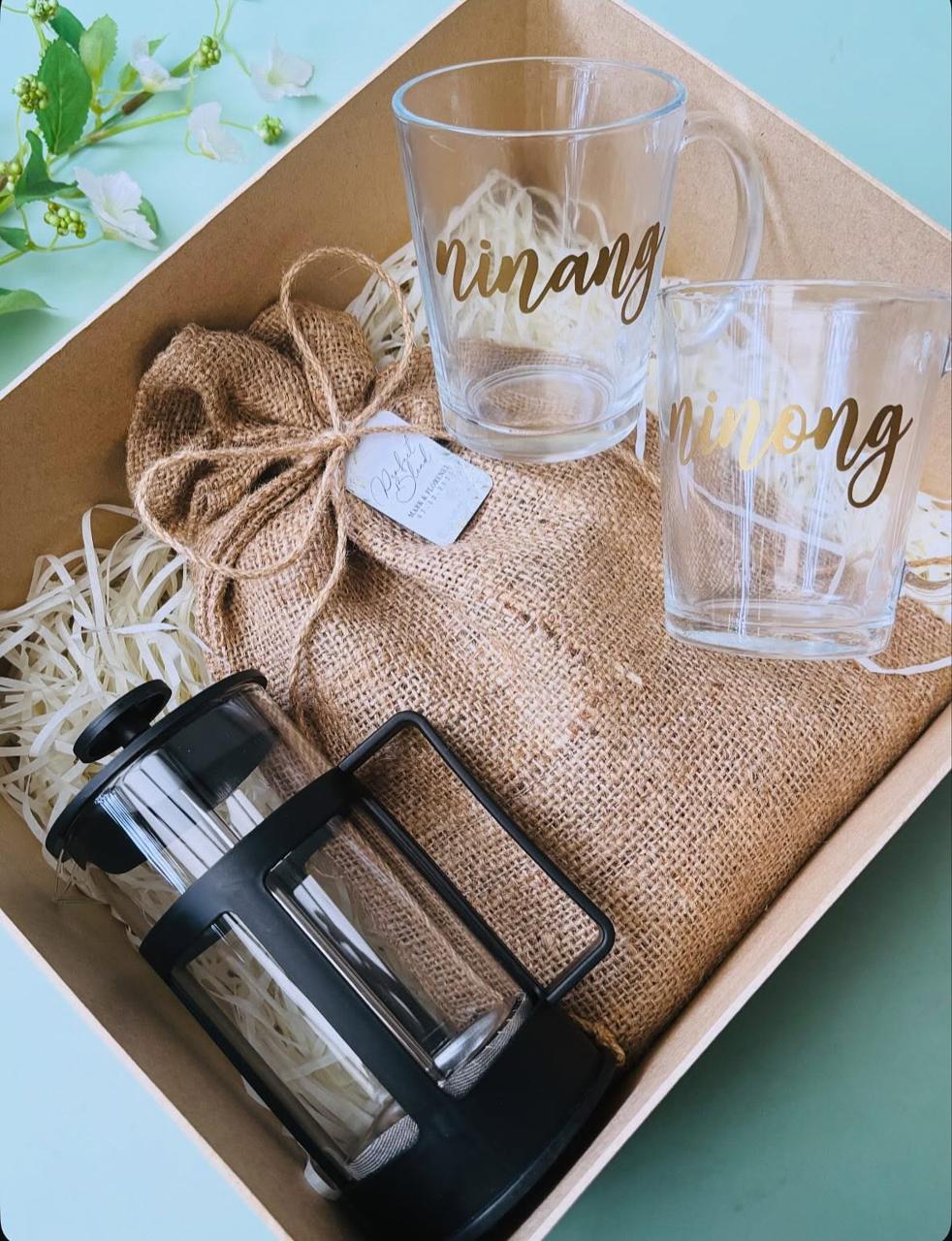 Personalized glass drinkware and a burlap pouch arranged in an Eve & Alice gift box