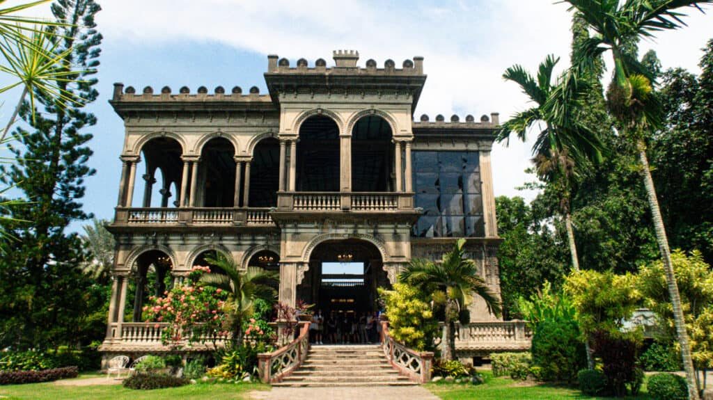 Historic two-story mansion with arched windows and a garden in Bacolod